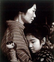 Oshin và mẹ trước lúc em phải đi ở đợ khi lên 7 với con búp bê gỗ Kokeshi trên tay.